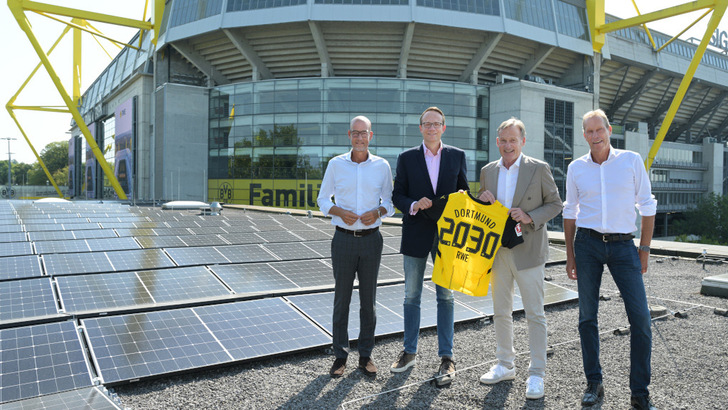 Auf dem Dach der Fanwelt des BVB ist schon eine Solaranlage installiert. Der Generator auf dem Stadiondach folgt bald. Carsten Cramer, Geschäftsführer des BVB, Markus Krebber, CEO von RWE, Hans-Joachim Watzke, Vorsitzender der Geschäftsführung des BVB, und Ulf Kerstin, CCO von RWE Supply & Trading (v.l.n.r.), besiegeln die neue Energiepartnerschaft. - © Andre Laaks, RWE