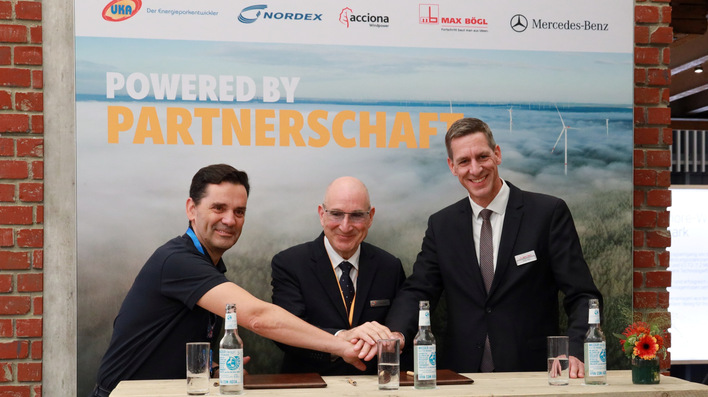 © Nordex Nordex-CEO José Luis Blanco, UKA-Geschäftsführer Gernot Gauglitz, Max-Bögl-Vorstandsvorsitzender Stefan Bögl (von links) beim Handschlag bei der Husum Wind 2025 nach der Vertragsunterzeichnung für Windpark Papenburg zur Direktversorgung von Mercedes Benz