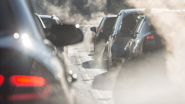 Autos, die im Stau stehen, stoßen Abgase aus und sorgen für eine sichtbare Luftverschmutzung an einer stark befahrenen Straße. - © Adobe.stock.com